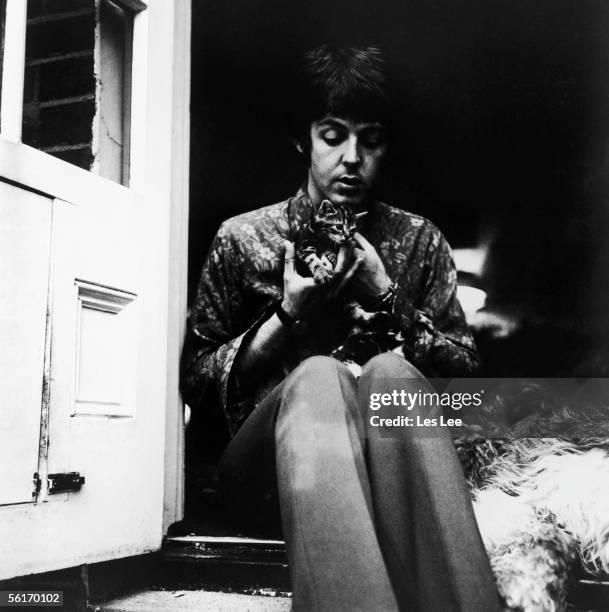 Beatle Paul McCartney sitting on the doorstep of his St John's Wood home with two kittens and an old English sheepdog, 20th June 1967.