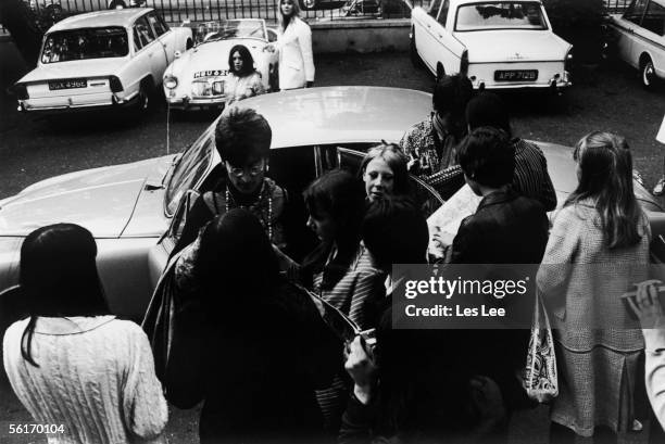 John Lennon and Paul McCartney signing autographs for fans as they arrive at EMI studios, Abbey Road, for a rehearsal with the Beatles during the...