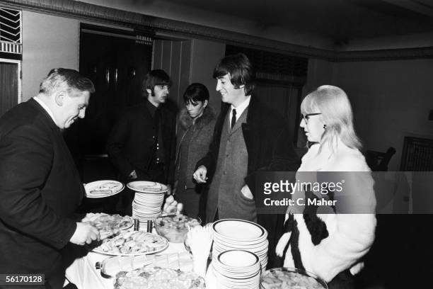 John Lennon and Ringo Starr of the Beatles queue for food in the bar of the Saville Theatre in London, after an Arts Theatre premiere, 17th February...
