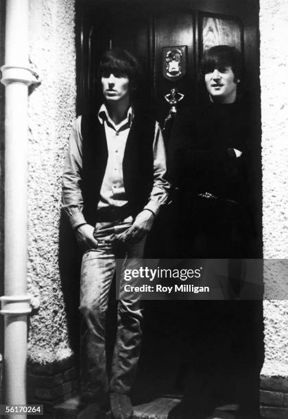 George Harrison and John Lennon pictured on a doorstep, after the announcement that The Beatles have been awarded MBEs in the Queen's birthday...