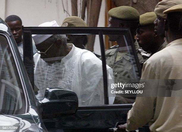 Chad's former President Hissene Habre gets in a car surrounded by prison guards, 15 November 2005, upon leaving the Court of Appeal in Dakar,...