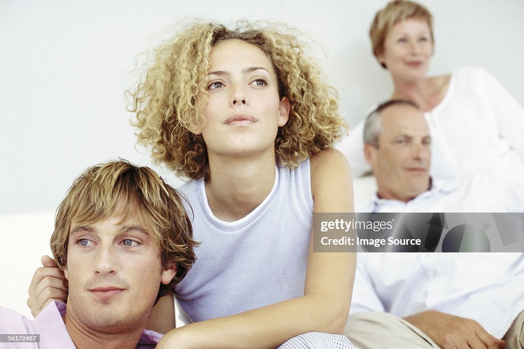 Young couple with in-laws in the background