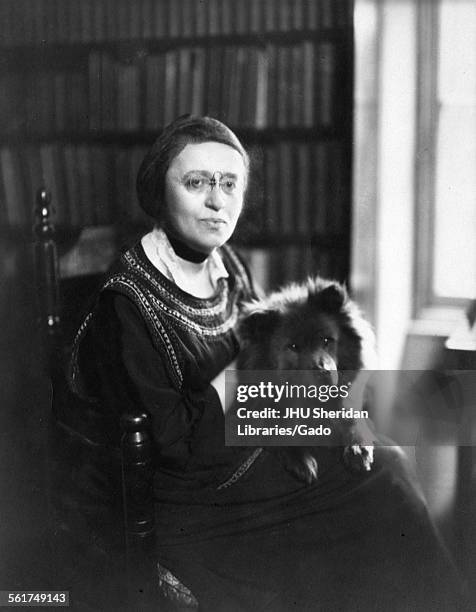 Elisabeth Gilman, portrait photograph with dog, sitting, waist up, three-quarter view, c50 years of age, 1915.