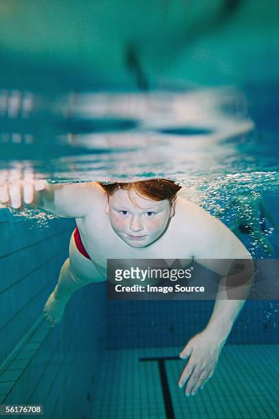boy swimming underwater - chubby kid stock-fotos und bilder
