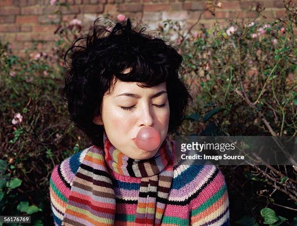 woman blowing a bubble gum bubble - bubble gum bubble stock pictures, royalty-free photos & images