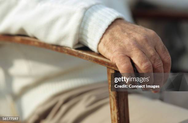 man's hand resting on chair - knuckles stock pictures, royalty-free photos & images