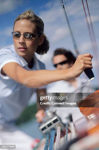 woman turning crank handle - squadra di vela foto e immagini stock