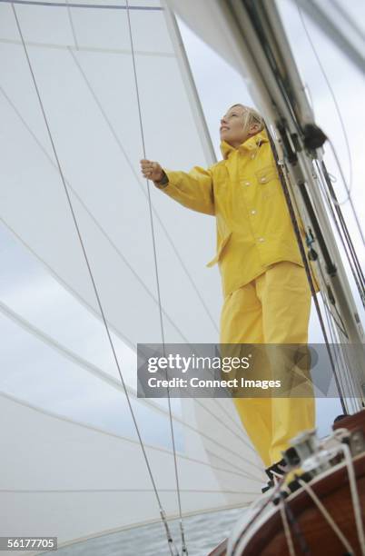 woman adjusting sail on boat - rainwear stock pictures, royalty-free photos & images