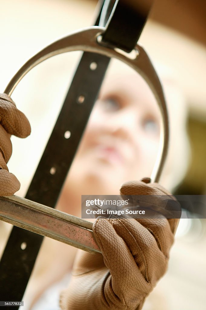 Young woman holding a stirrup