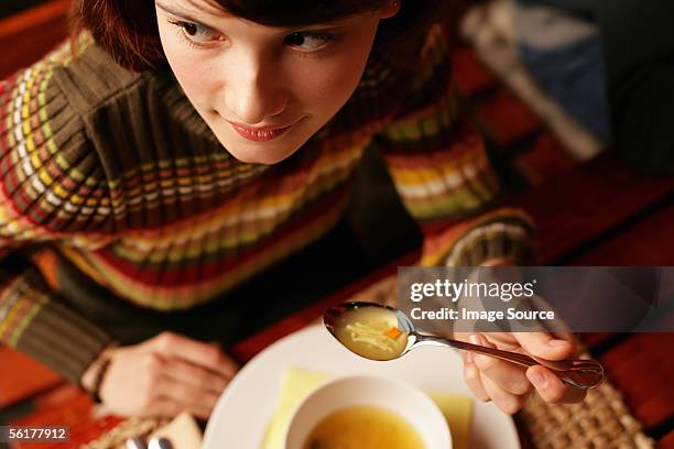 young woman eating soup - eating soup stock pictures, royalty-free photos & images