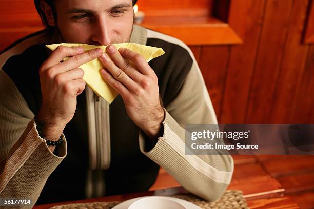 man wiping his mouth with napkin - reibe stock-fotos und bilder