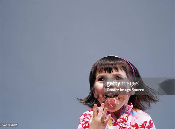 girl with crumbs round her mouth - messy cake stock pictures, royalty-free photos & images
