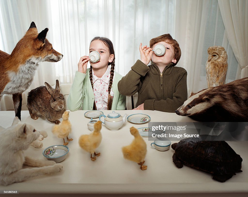 Children having a tea party with animals