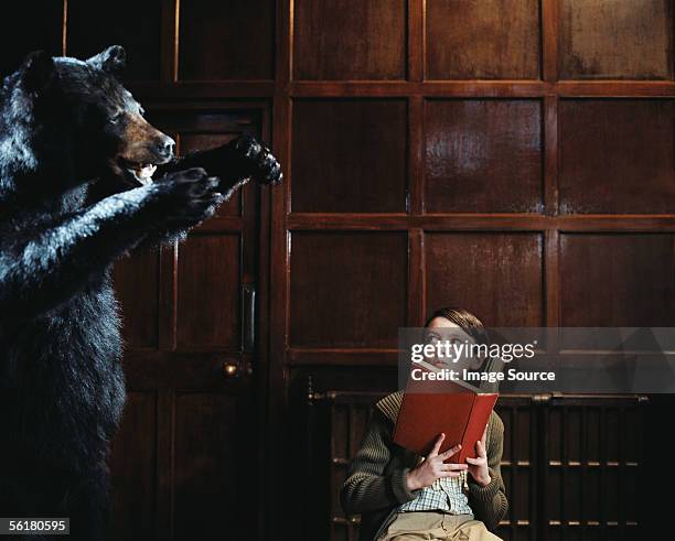 junge mit buch mit teddybär - bear attacking stock-fotos und bilder