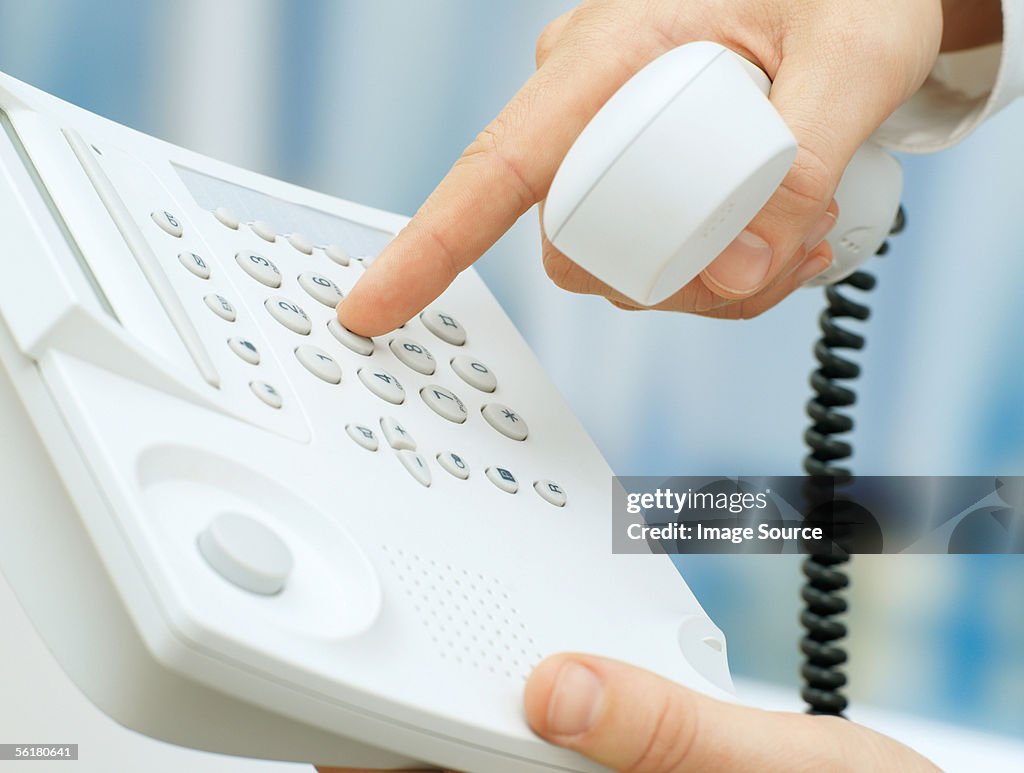 Person dialing telephone