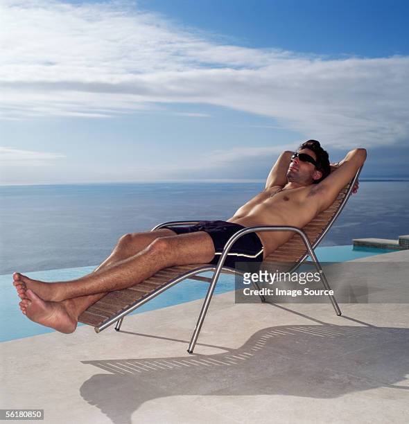 man relaxing by the pool - homem moreno imagens e fotografias de stock
