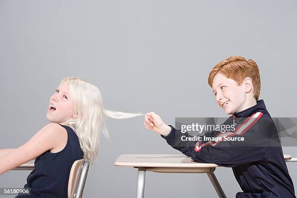 boy pulling girl's hair - rough housing imagens e fotografias de stock