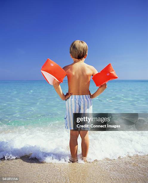boy paddling with arm bands - arm band stock pictures, royalty-free photos & images