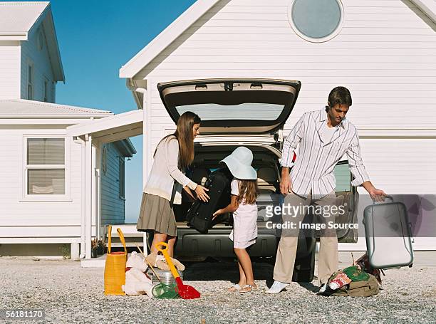 family unpacking luggage from the car - car arrival stock pictures, royalty-free photos & images