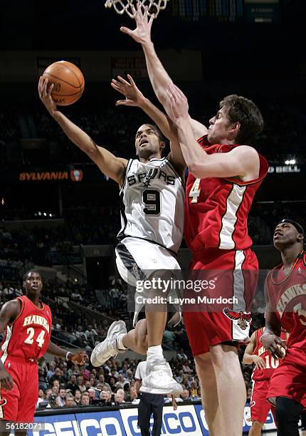 Tony Parker of the San Antonio Spurs shoots the ball between Al Harrington and Marvin Williams of the Atlanta Hawks on November 15, 2005 at the SBC...