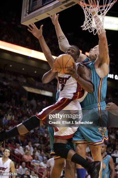 Guard Dwyane Wade of the Miami Heat tangles with Chris Anderson of the New Orleans/Oklahoma City Hornets in the fourth period on November 15, 2005 at...