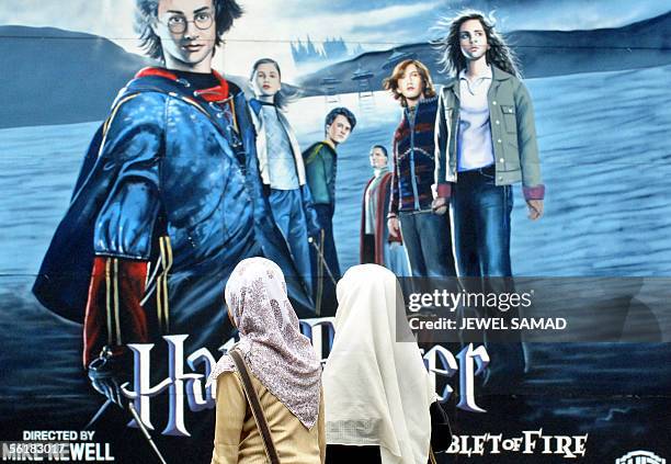 Two school girls walk past a huge billboard for the latest Harry Potter movie, "Harry Potter and the Goblet of Fire," in Jakarta, 16 November 2005....