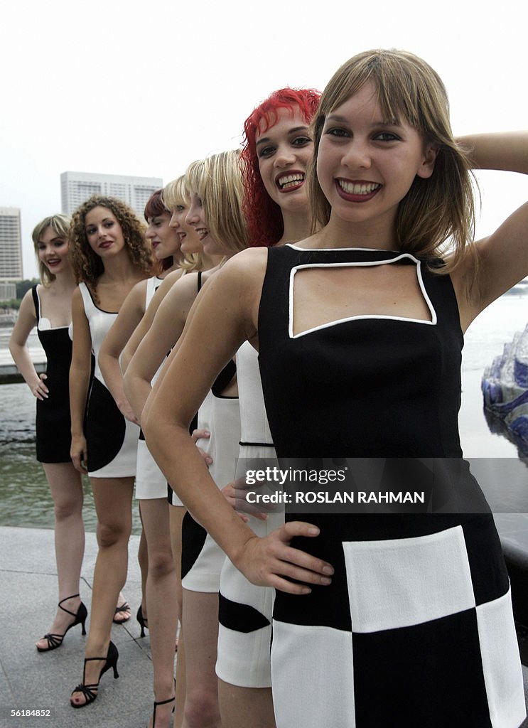 Crazy Horse Paris dancers pose next to t