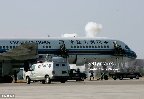 Special policemen try to enter an aircraft to rescue hostages during an anti-hijack drill at Baiyun International Airport on November 16, 2005 in...