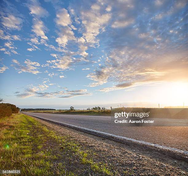 country road at sunset - roadside photos et images de collection