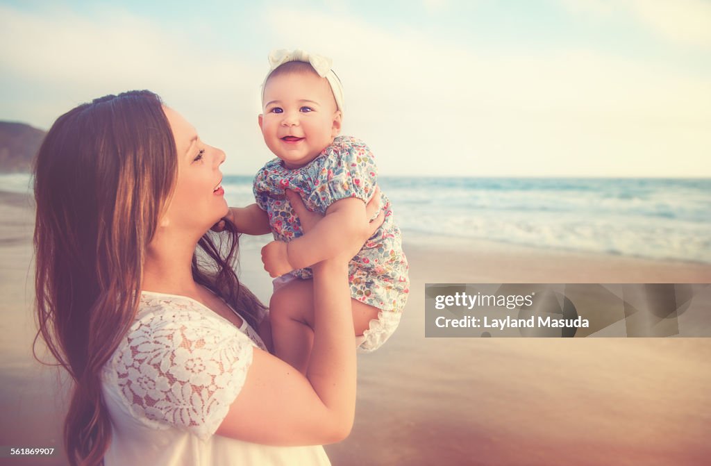 Mommy holding baby on a beach