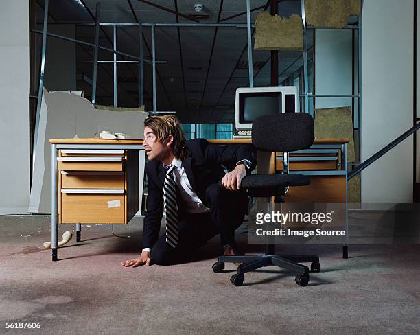 businessman emerging from under desk - earthquake stock pictures, royalty-free photos & images