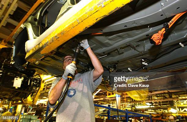 Auto worker David Baker installs a high-voltage power line into the chassy of a Mercury Mariner Hybrid SUV at the Kansas City Assembly Plant November...