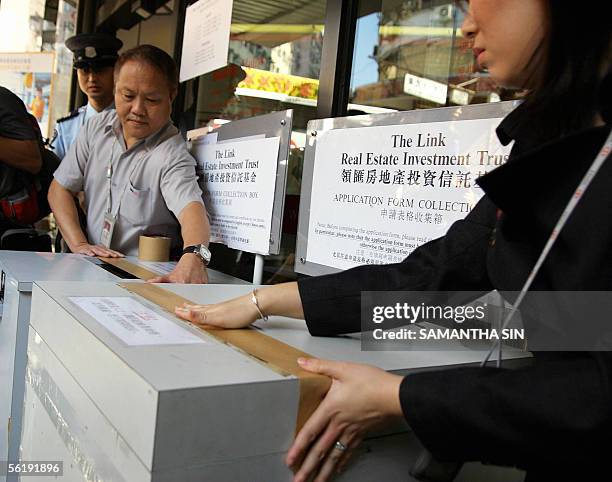 Bank staff seal the collection box for The Link Real Estate Investment Trust during the last day of the retail portion of the IPO in Hong Kong on 17...