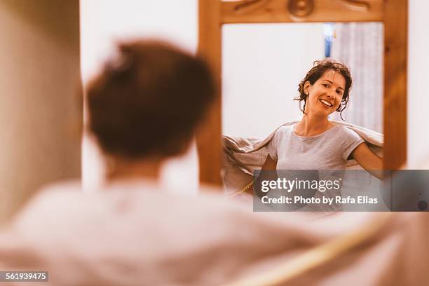 pretty smiling woman with shawl looking in mirror - woman full length mirror stock pictures, royalty-free photos & images