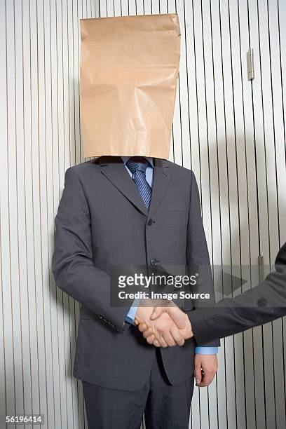 businessman with paper bag on head - awkward handshake stock pictures, royalty-free photos & images