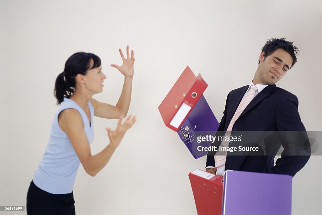 Woman throwing folders at man