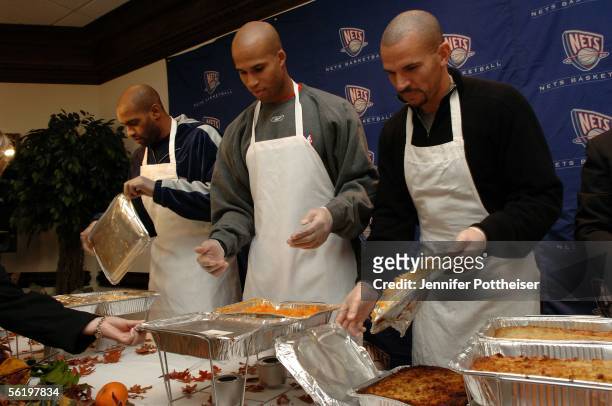 Vince Carter, Richard Jefferson and Jason Kidd of the New Jersey Nets dish out food to guests at the Christian Cultural Center November 17, 2005 in...