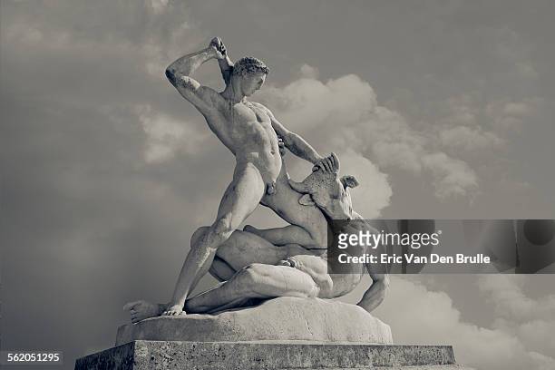 sculpted figures of a man fighting a minotaur - minotauro fotografías e imágenes de stock