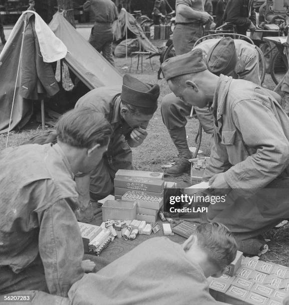 War 1939-1945. Liberation of Paris. Soldiers of the 2nd A.D. With the wood of Boulogne. Sharing tobacco, chewing-gum, chocolate, tooth powder etc......