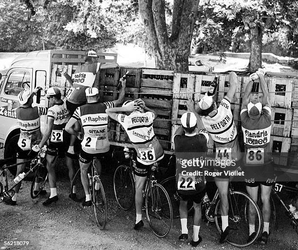 Racing cyclists getting fresh supplies in the during the 11th stage of the Tour de France between Toulon and Montpelier, 2nd July 1964. From left to...