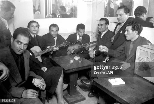 Django Reinhardt , guitarist of jazz with gypsy musicians, in a bar. From left to right : Baro Ferret, Lousson Baughtmauter , Reinhardt and Sarane...