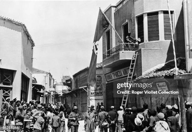 War 1939-1945. Invasion of the Greece by Germans. German troups runing up flags with swastika on the Market place of Moudros in the Lemnos island....