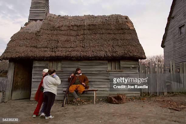 Francis Billington sits outside his father's home as he reenacts a scene from the 1627 Pilgrim Village at "Plimoth Plantation" where role-players...