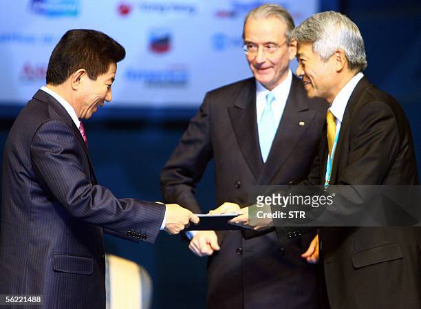 South Korean President Roh Moo-hyun receves from Hyun Jae-hyun, chairman of South Korea's Dongyang Group, a copy of a document signed by 400 global...