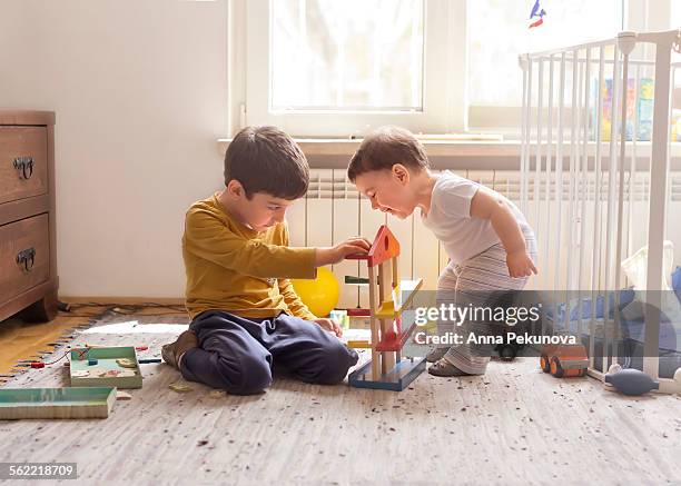 sibling playing together with wooden toy - messing about stock pictures, royalty-free photos & images