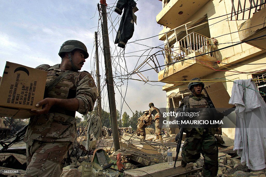 Iraqi soldiers carry boxes of US militar