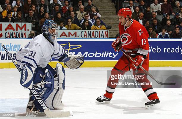 Curtis Joseph of the Toronto Maple Leafs defends against Bates Battaglia of the Carolina Hurricanes during the game at Air Canada Centre in Toronto,...
