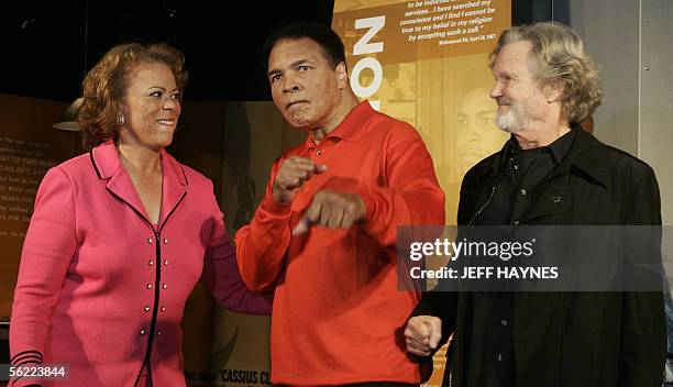 Louisville, UNITED STATES: Muhammad Ali strikes a boxing pose with wife Lonnie and musican Kris Kristofferson at the Muhammad Ali Center 18 November,...