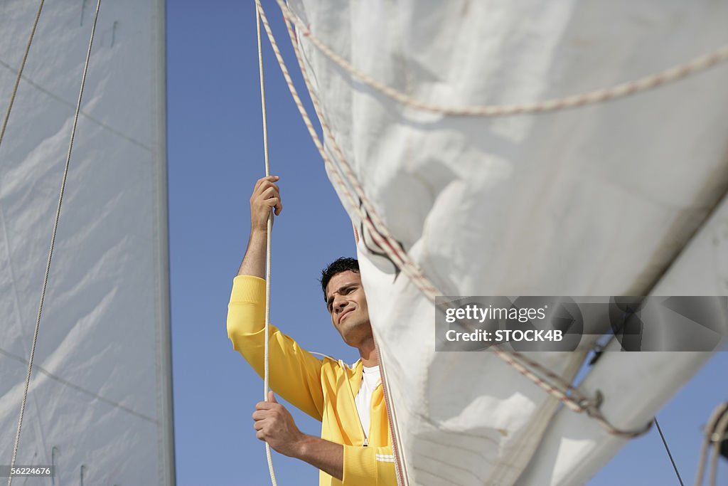 Man hoisting a sail