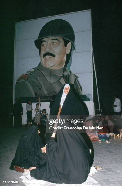 Shiite woman and portrait of Saddam Husayn during the Prophet's birthday. Irak, 1990.